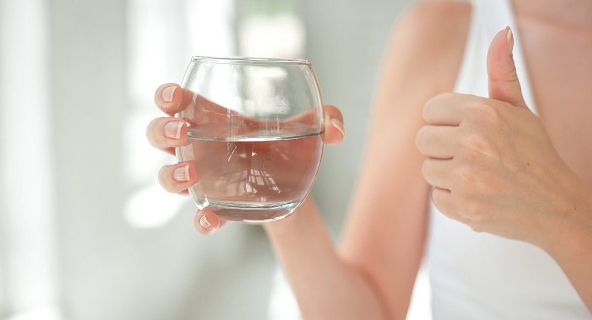 woman holding glass of fresh water - Aquafeel System concept image