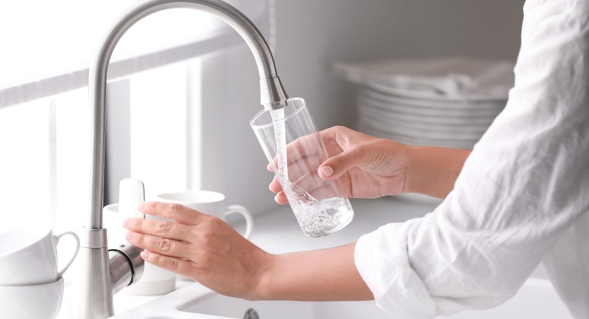 Person filling a glass of water - Water testing concept image